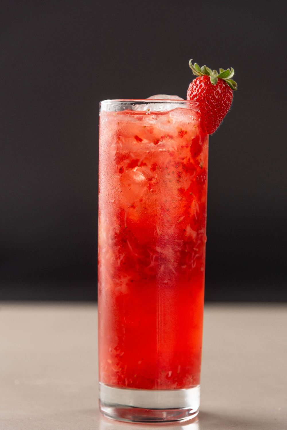 Drink vermelho em copo alto com morango